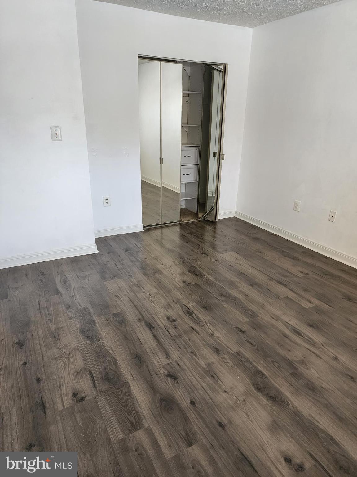 7603 Weather Worn Way, Unit F Columbia, MD 21046 - Photo 13 of 17 a view of an empty room with wooden floor and closet