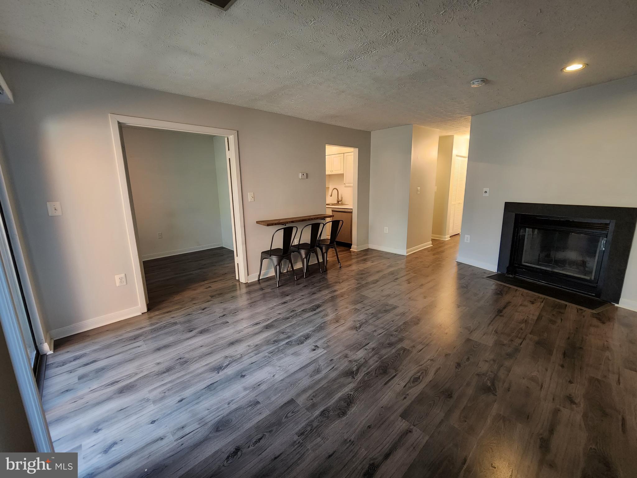 7603 Weather Worn Way, Unit F Columbia, MD 21046 - Photo 2 of 17 an empty room with wooden floor and fireplace