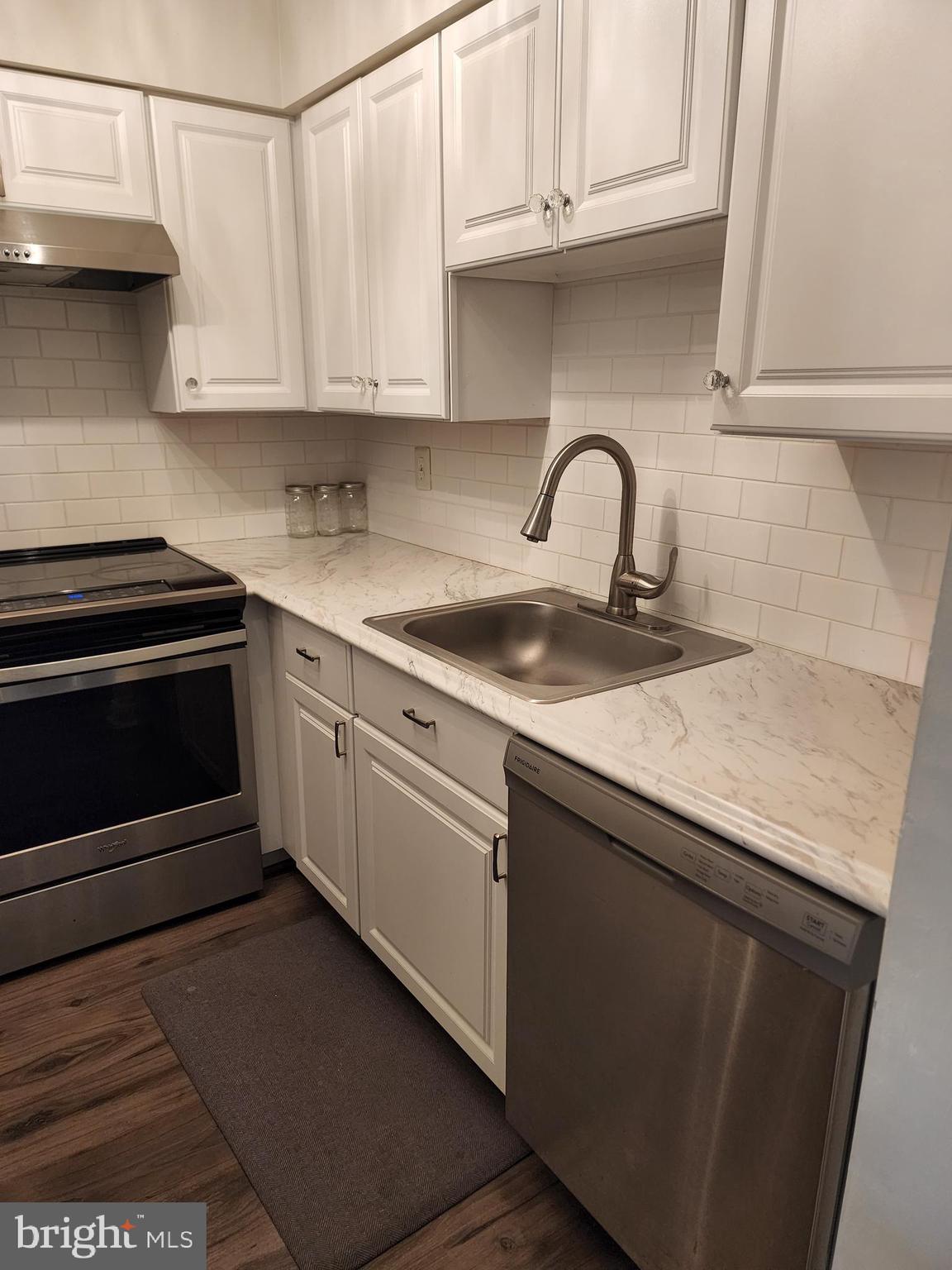 7603 Weather Worn Way, Unit F Columbia, MD 21046 - Photo 6 of 17 a kitchen with granite countertop white cabinets and stainless steel appliances