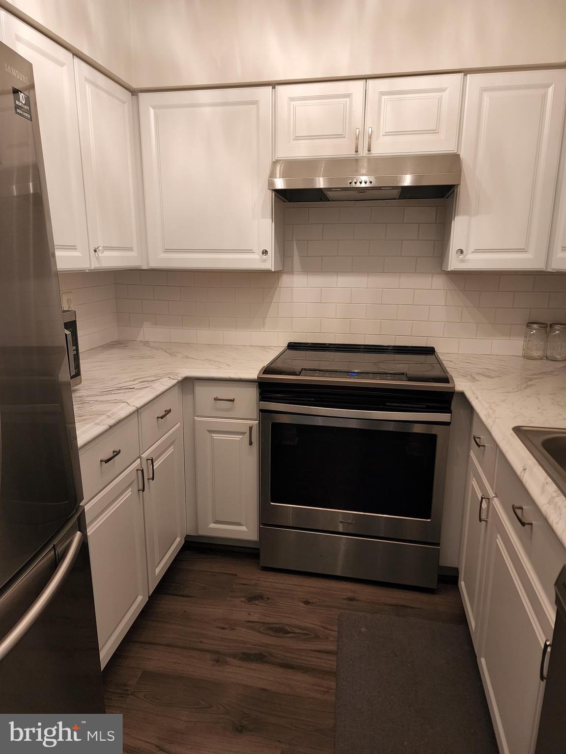 7603 Weather Worn Way, Unit F Columbia, MD 21046 - Photo 7 of 17 a kitchen with stainless steel appliances granite countertop a stove and a white cabinets