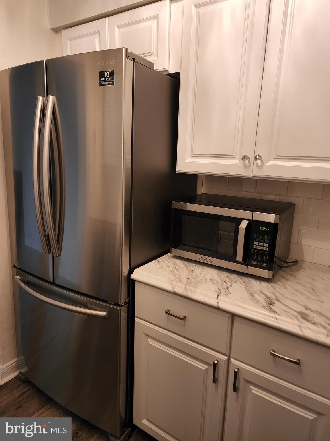 7603 Weather Worn Way, Unit F Columbia, MD 21046 - Photo 9 of 17 a kitchen with metallic refrigerator and cabinets