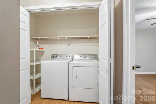 a view of a big room with wooden floor and a chandelier fan