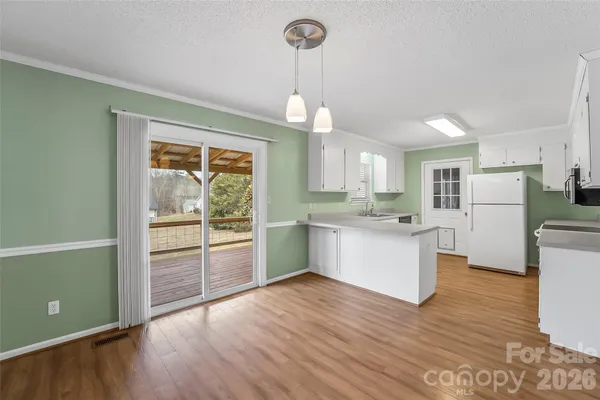 a kitchen with granite countertop white cabinets and stainless steel appliances