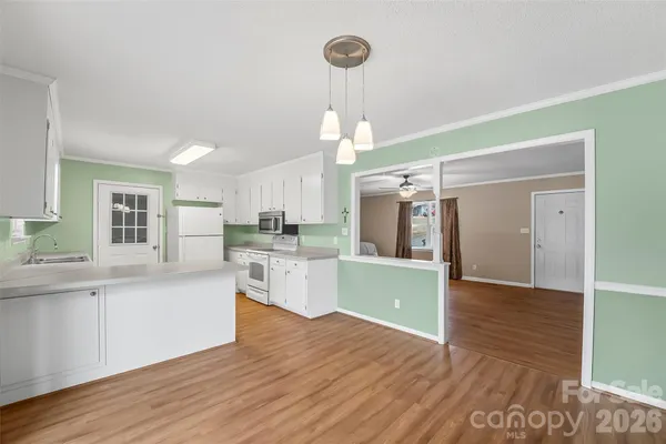 a kitchen with kitchen island granite countertop a sink a counter space appliances and cabinets