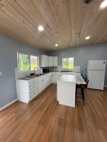 a large kitchen with stainless steel appliances granite countertop a lot of counter space and wooden floors