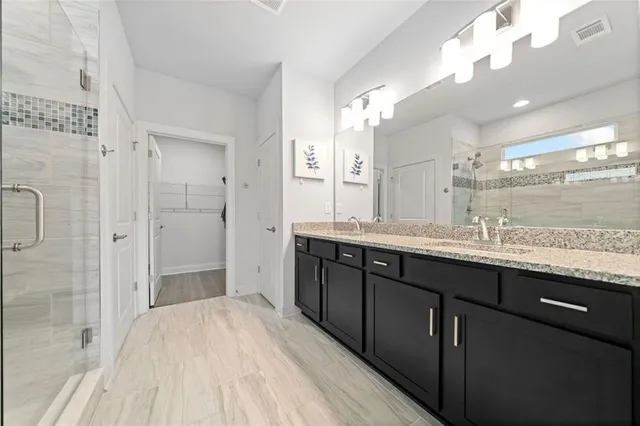 a spacious bathroom with a granite countertop sink mirror and a shower