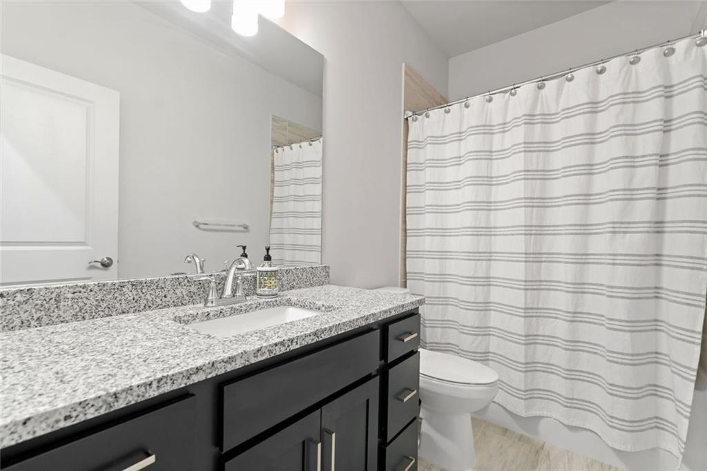 19 Grand Circle Jasper, GA 30143 - Photo 27 of 36 a bathroom with a granite countertop sink a toilet and a mirror