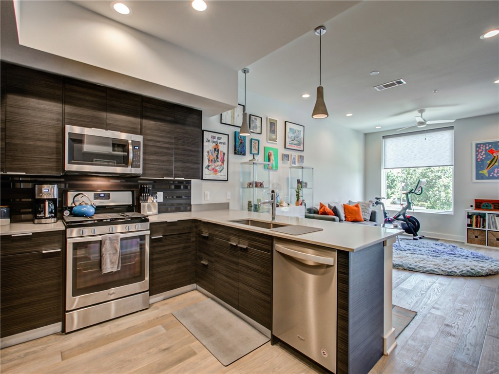 a kitchen with stainless steel appliances granite countertop a stove sink and microwave