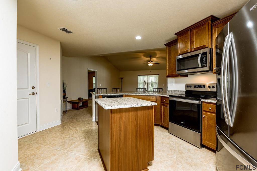 20 Turtle Ridge Drive Flagler Beach, FL 32136 - Photo 14 of 47 a kitchen with granite countertop a refrigerator stove and oven