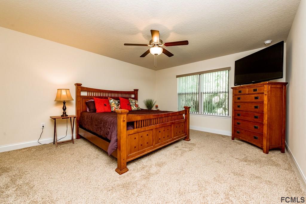 20 Turtle Ridge Drive Flagler Beach, FL 32136 - Photo 21 of 47 a bedroom with furniture and a flat screen tv