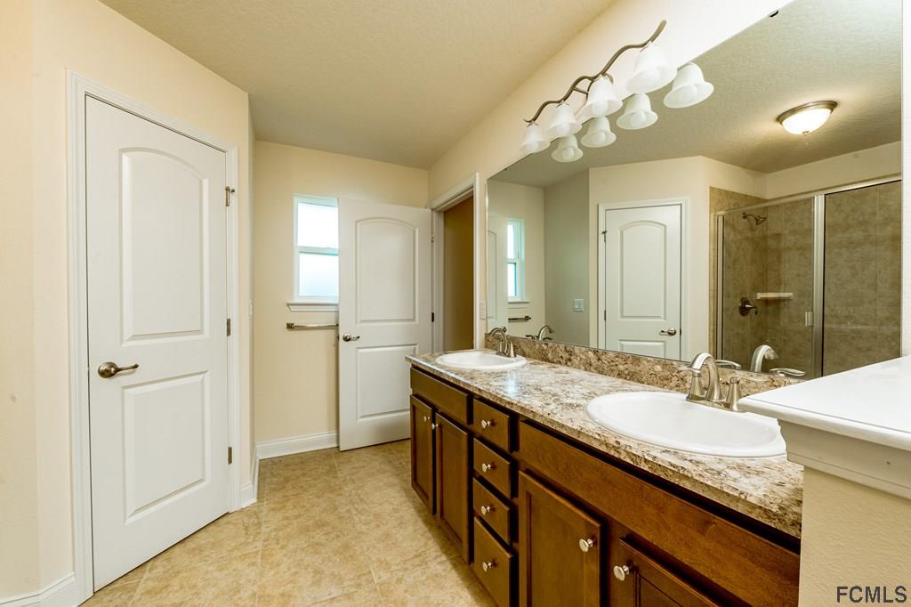 20 Turtle Ridge Drive Flagler Beach, FL 32136 - Photo 24 of 47 a spacious bathroom with a granite countertop sink a mirror and a shower