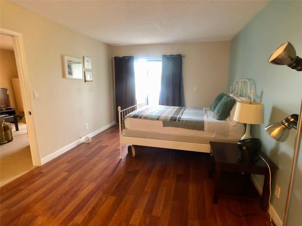 10026 Winding Lake Road, Unit 102 Sunrise, FL 33351 - Photo 11 of 23 a bedroom with furniture and wooden floor