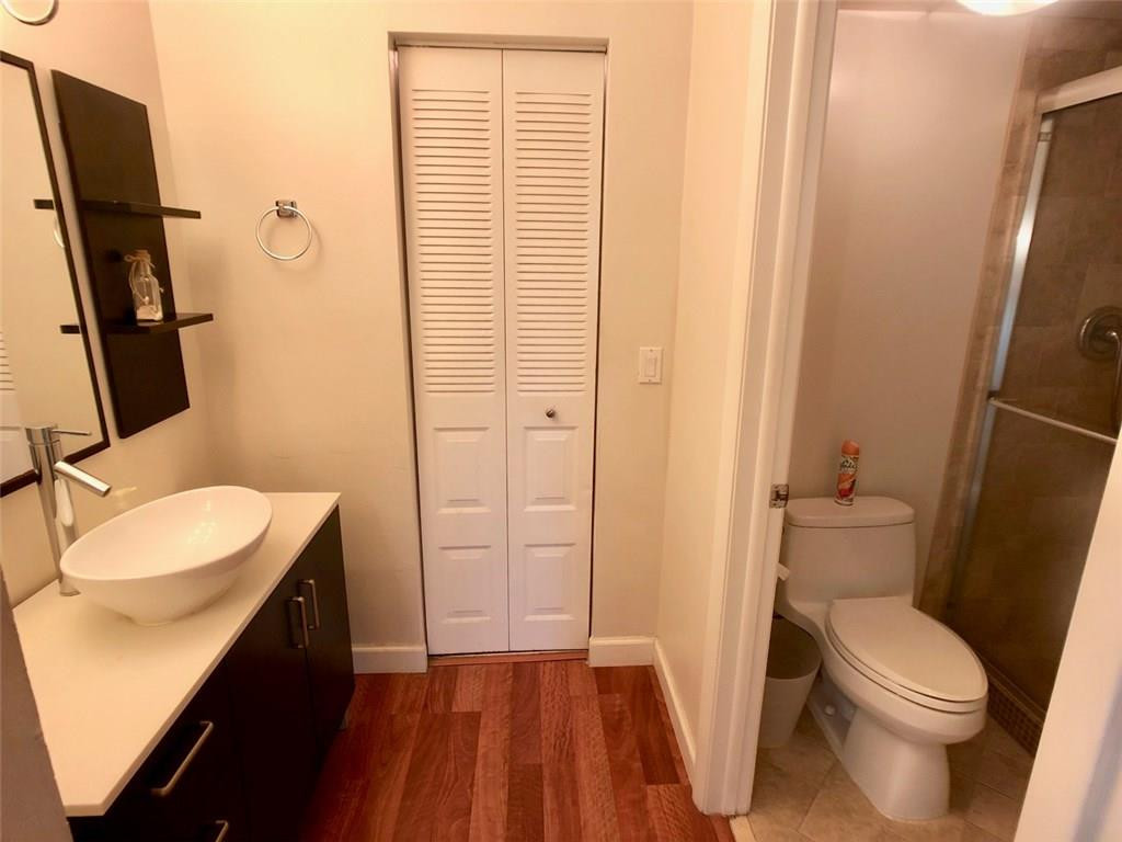 10026 Winding Lake Road, Unit 102 Sunrise, FL 33351 - Photo 13 of 23 a bathroom with a sink a toilet a mirror and shower