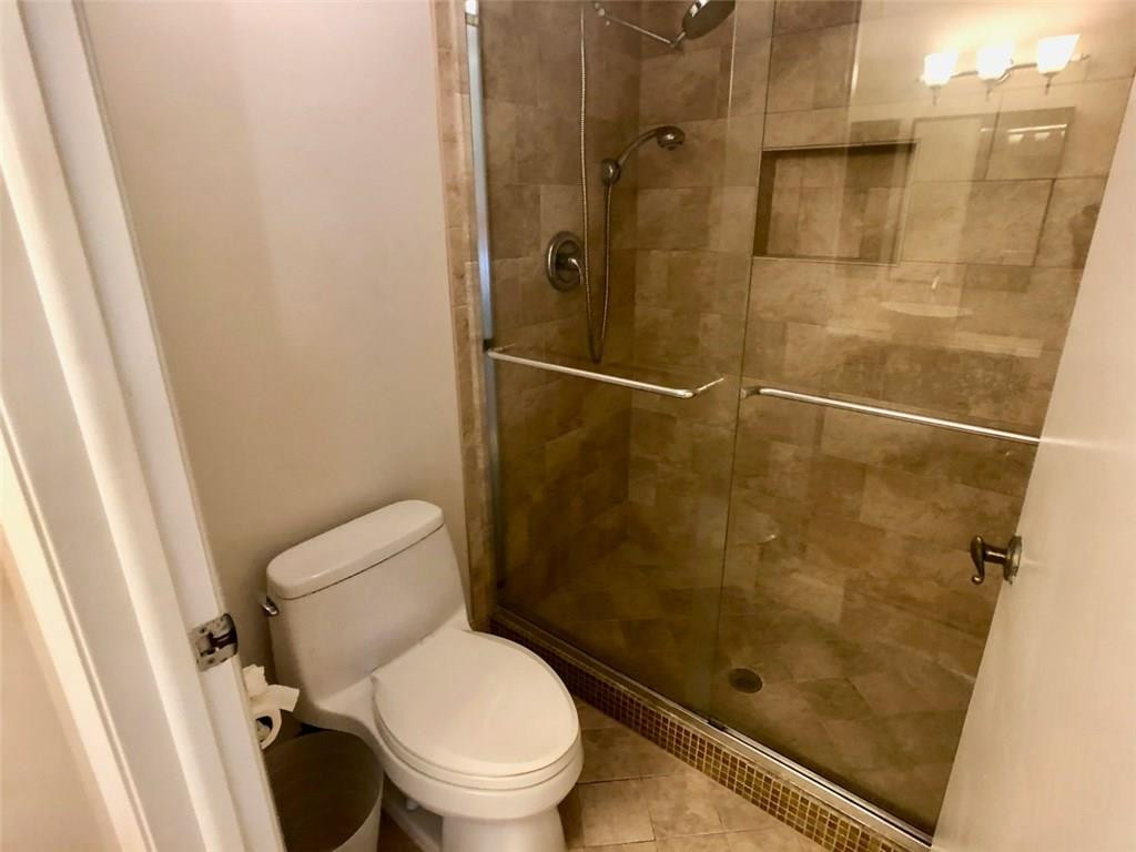 10026 Winding Lake Road, Unit 102 Sunrise, FL 33351 - Photo 15 of 23 a bathroom with a toilet and a shower
