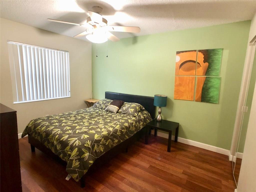10026 Winding Lake Road, Unit 102 Sunrise, FL 33351 - Photo 17 of 23 a bedroom with a bed and a chair