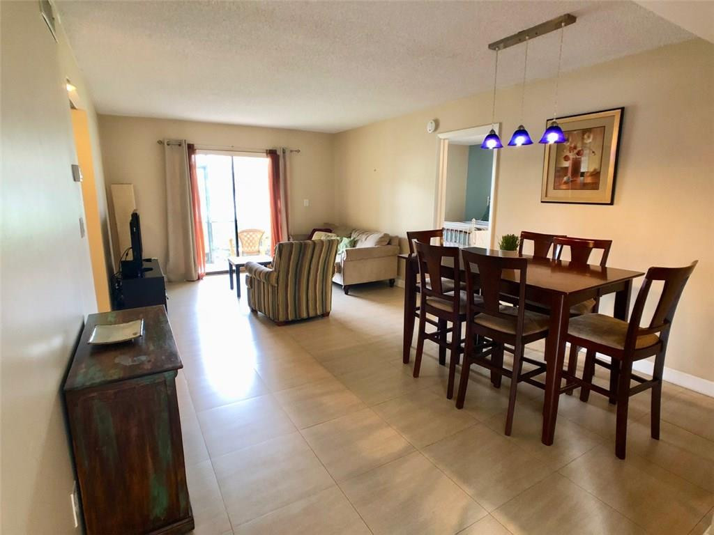 10026 Winding Lake Road, Unit 102 Sunrise, FL 33351 - Photo 4 of 23 a view of a dining room with furniture window and wooden floor