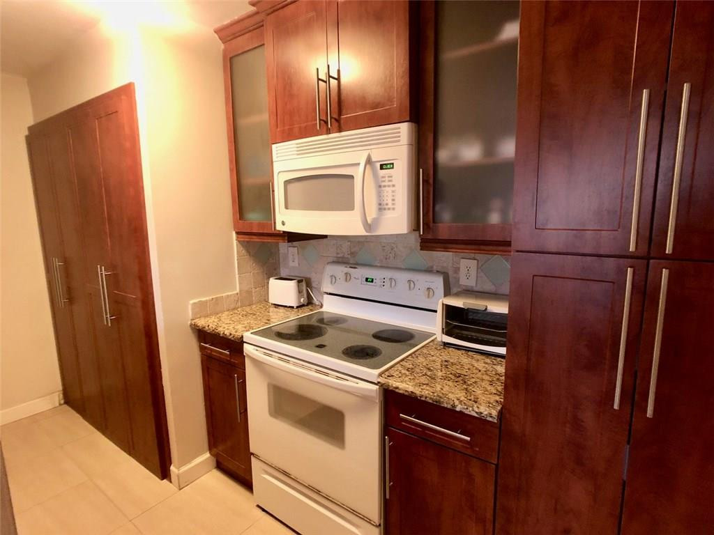 10026 Winding Lake Road, Unit 102 Sunrise, FL 33351 - Photo 7 of 23 a kitchen with a stove microwave and refrigerator
