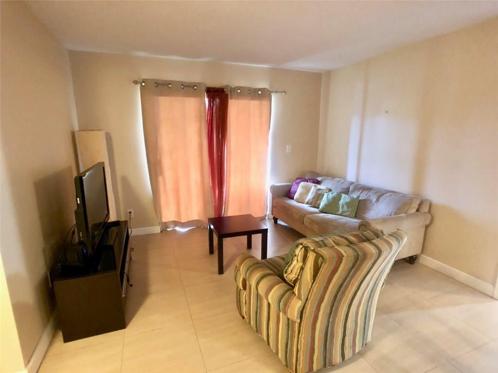 10026 Winding Lake Road, Unit 102 Sunrise, FL 33351 - Photo 9 of 23 a bedroom with a bed and a flat screen tv