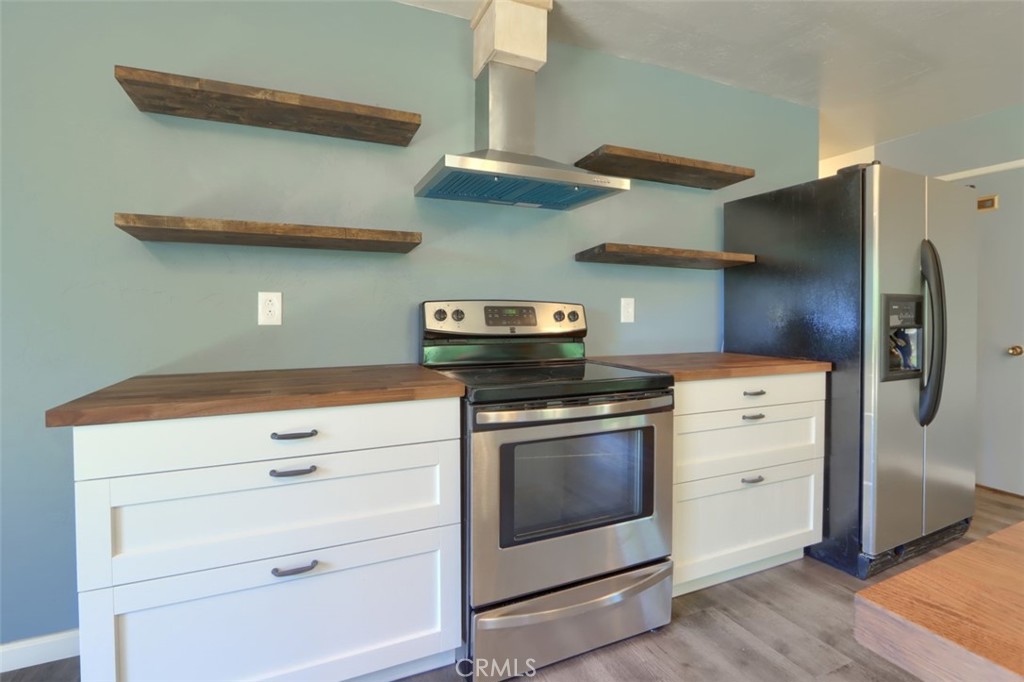4949 Indian Peak Road Mariposa, CA 95338 - Photo 16 of 56 a kitchen with stainless steel appliances cabinets and a wooden floor