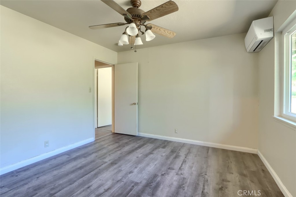 4949 Indian Peak Road Mariposa, CA 95338 - Photo 21 of 56 an empty room with wooden floor and windows