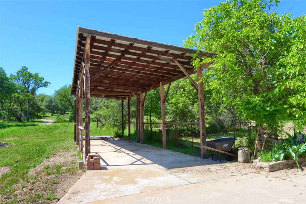 4949 Indian Peak Road Mariposa, CA 95338 - Photo 46 of 56 a view of a patio with a table and chairs under an umbrella with a small yard