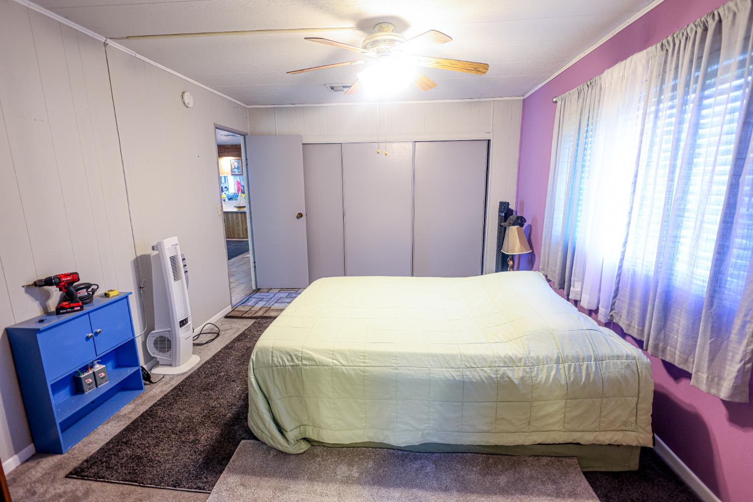 1300 West Olson Avenue, Unit 61 Reedley, CA 93654 - Photo 13 of 20 a spacious bedroom with a bed and a chandelier