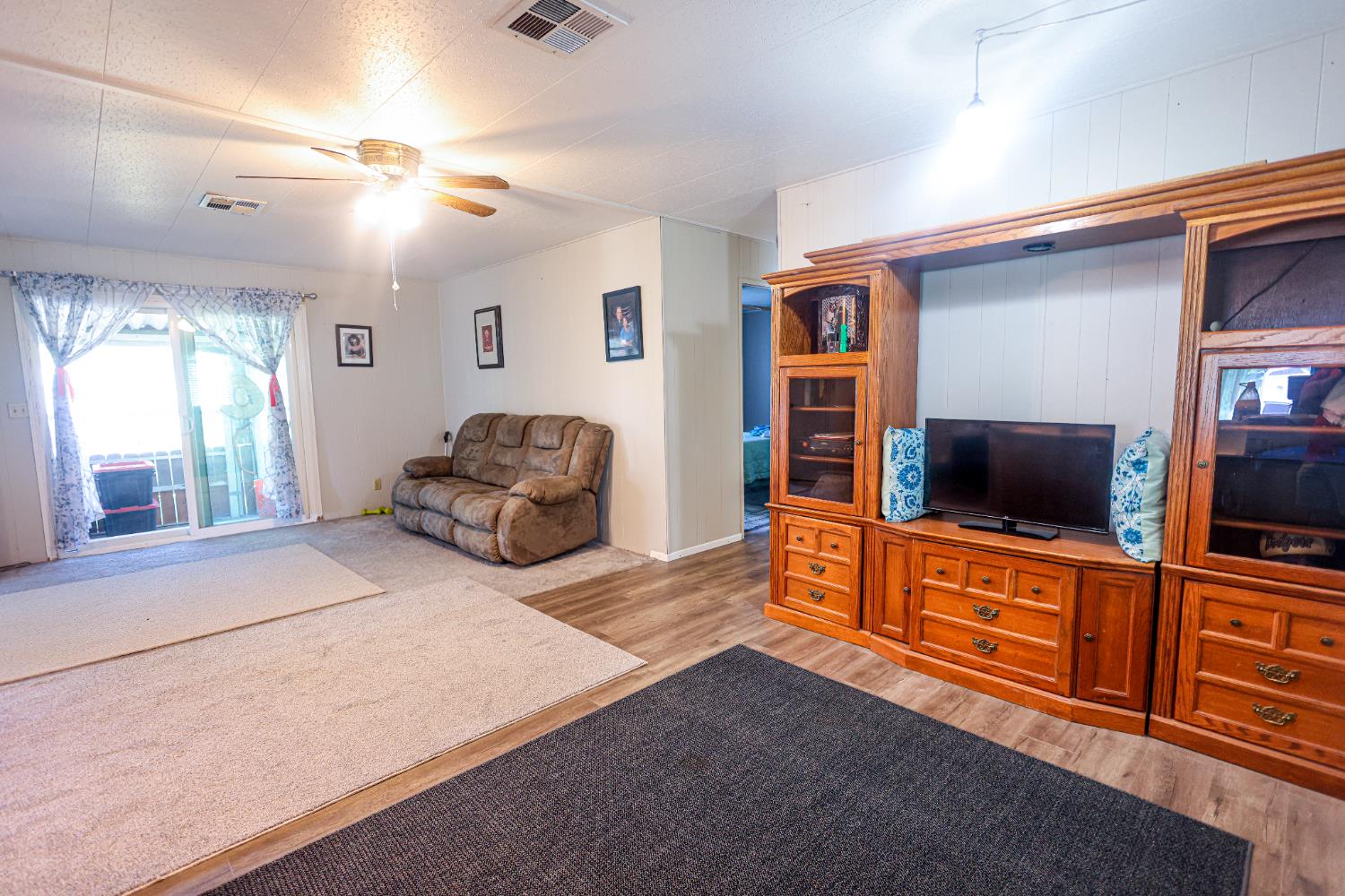 1300 West Olson Avenue, Unit 61 Reedley, CA 93654 - Photo 8 of 20 a living room with furniture and a flat screen tv