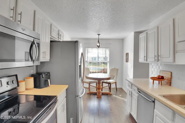 a kitchen with stainless steel appliances granite countertop a sink stove and cabinets