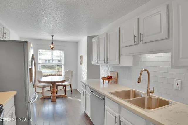 a kitchen with stainless steel appliances granite countertop a sink and cabinets