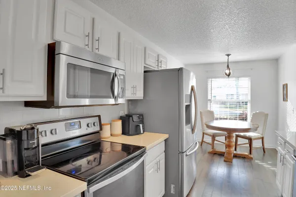 a kitchen with stainless steel appliances granite countertop a refrigerator stove top oven and sink