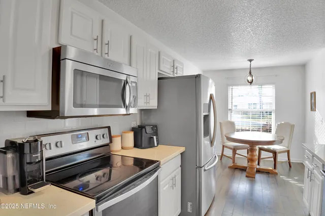 a kitchen with stainless steel appliances granite countertop a refrigerator stove top oven and sink