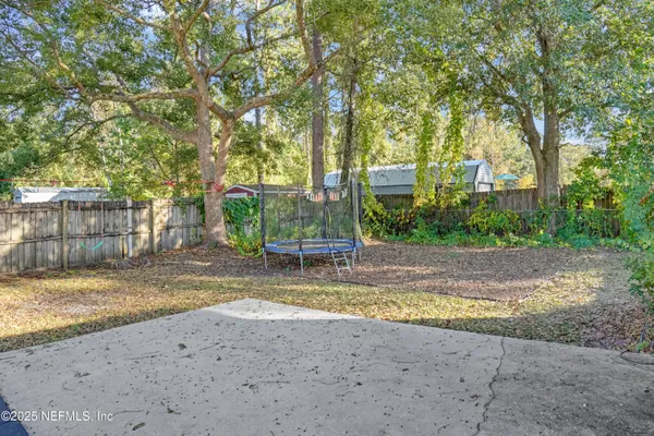 a view of a yard with a house and large tree