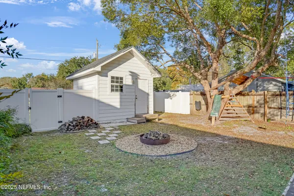 a view of a white house with a yard and large tree