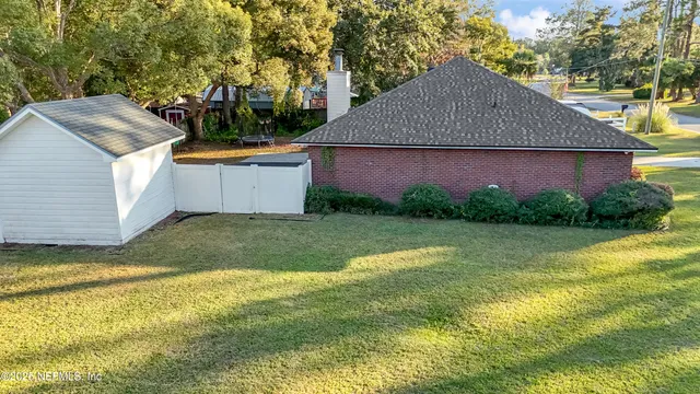 a view of a house with a yard potted plants and a large tree