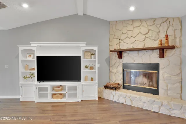 a living room with a fireplace a flat screen tv and a rug