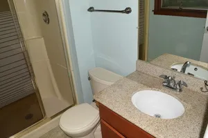 a bathroom with a granite countertop sink toilet and mirror