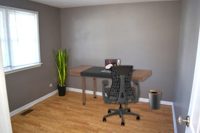 a view of a workspace with furniture and a window