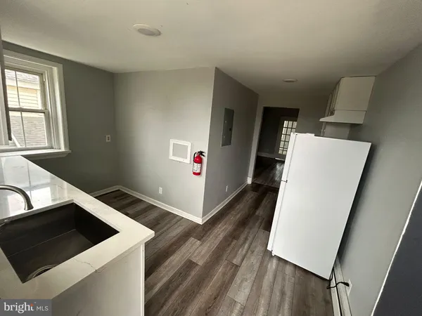 a view of a kitchen with fridge and wooden floor