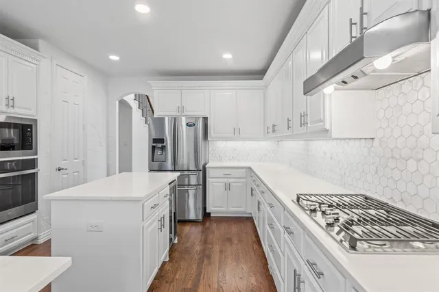 a kitchen with refrigerator a stove and cabinets