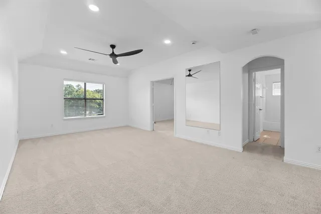 en empty room with windows and ceiling fan