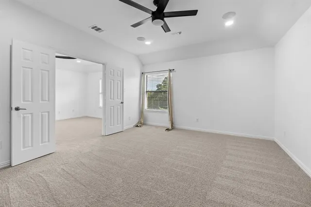 an empty room with chandelier fan