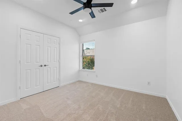 an empty room with a window and a ceiling fan