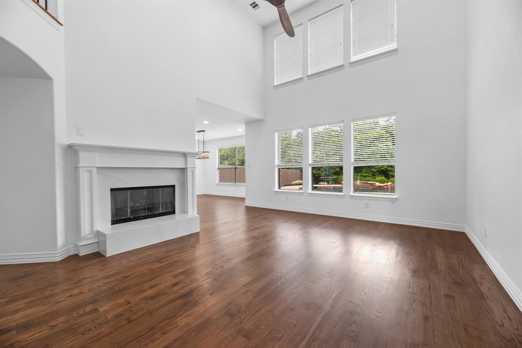 1013 Siena Drive Southlake, TX 76092 - Photo 8 of 31 an empty room with wooden floor fireplace and windows