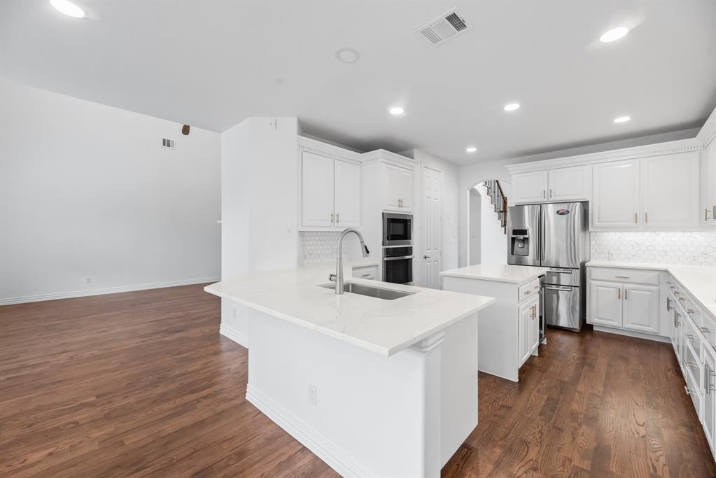 1013 Siena Drive Southlake, TX 76092 - Photo 10 of 31 a kitchen with stainless steel appliances a refrigerator sink and white cabinets