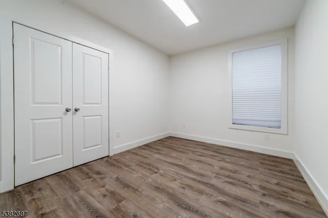 a view of an empty room with closet and a window