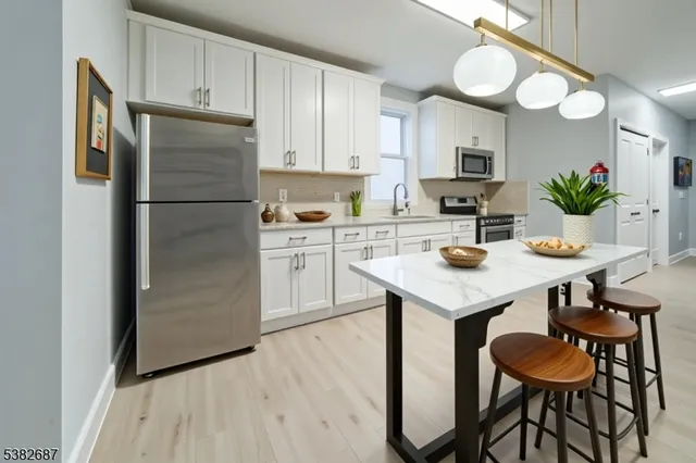 a kitchen with a refrigerator a stove a sink and chairs