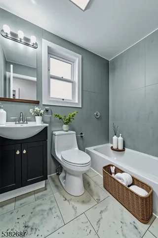 a bathroom with a toilet a sink and mirror