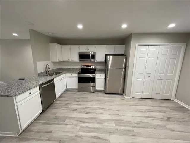 a large kitchen with a refrigerator sink and cabinets