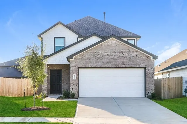 a front view of a house with a garden and plants