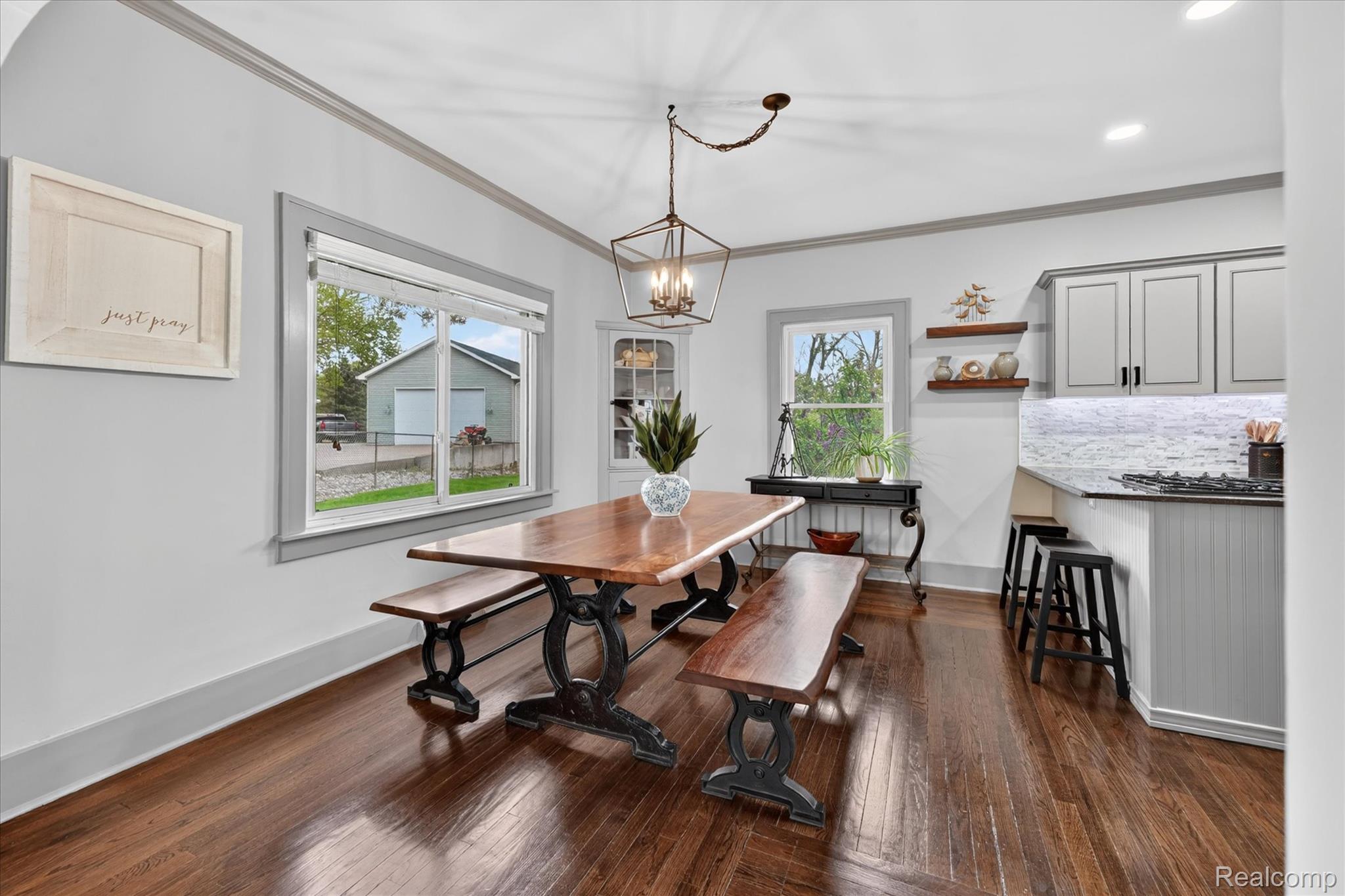 12409 Fenton Road Fenton, MI 48430 - Photo 6 of 61 Dining space with dark wood finished floors, crown molding, and hanging lights